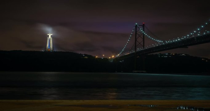 Lisbon Bridge and Christ the King night timelapse. Clouds moving fast.