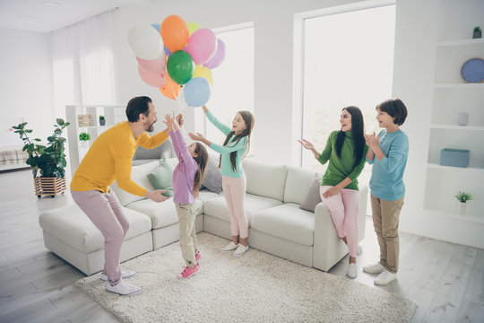 Full size photo of positive fun cheerful people family enjoy celebrating woman anniversary day launch many air baloons three little kids daddy mommy sit cozy couch in house