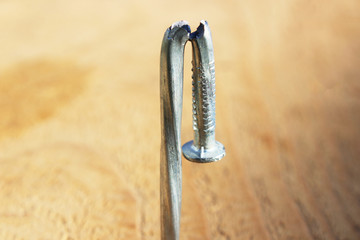 Faulty new metal nail macro. Bent damaged product. Reject expendable material.