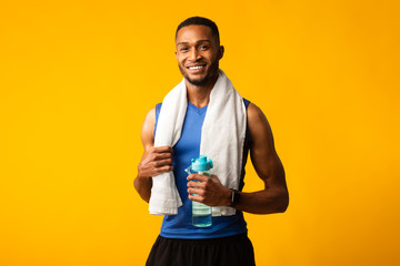 Healthy afro guy holding bottle of water