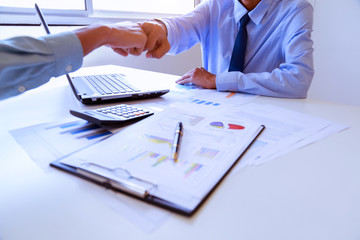Real estate broker and customer shaking hands after signing a contract: real estate, home loan and insurance concept.