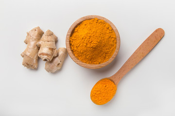 Turmeric root and turmeric powder on white
