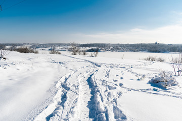 Fototapeta na wymiar Spacious snow landscape. River and hills in Russia, white winter on the terrain, a lot of fluffy snow and ice under a beautiful blue sky. Rostov region, town of Shakhty, the river Grushevka