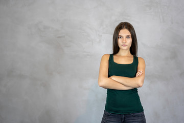 Young pretty woman with angry disappointed face cross hands on grey background. copy space