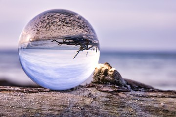 Lensball as the subject on a piece of driftwood during a beautiful sunset at the beach