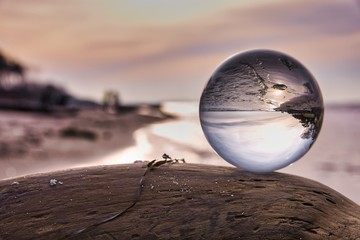 Lensball as the subject on a piece of driftwood during a beautiful sunset at the beach