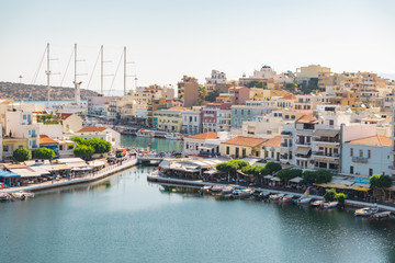 Fototapeta na wymiar Agios Nikolaos, Crete, Greece. 2019. View of Lake Voulismeni on the northwest side of Mirabello Bay, as well as the harbor and city with fishing boats and restaurants