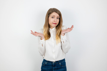 young beautiful blond woman standing on isolated white background looking innocent , body language...
