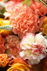 Yellow and orange roses bouquet on a rustic wooden background 