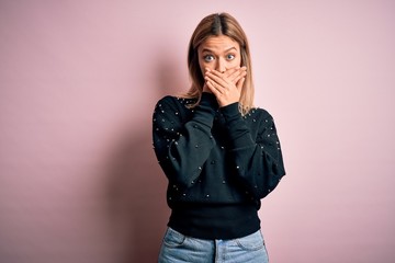 Young beautiful blonde woman wearing fashion sweater over pink isolated background shocked covering mouth with hands for mistake. Secret concept.