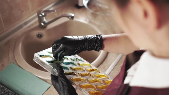 Female hand cleaning painted chocolate palette at the kitchen