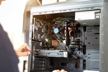Technician with a screwdriver for fixing computers, computer har;