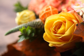 Yellow and orange roses bouquet on a rustic wooden background 