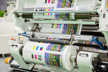 Large offset printing press or magazine running a long roll off paper in production line of...