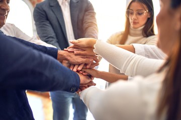 Group of business workers standing with hands together at the office