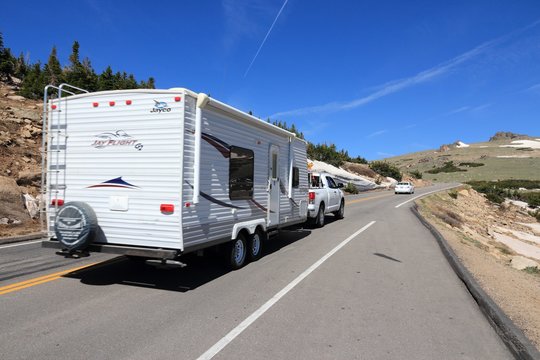 ROCKY MOUNTAINS, USA - JUNE 19, 2013: People drive with camping trailer along Trail Ridge Road in Rocky Mountain National Park, Colorado. RNMP has 3,176,941 annual visitors (2011).
