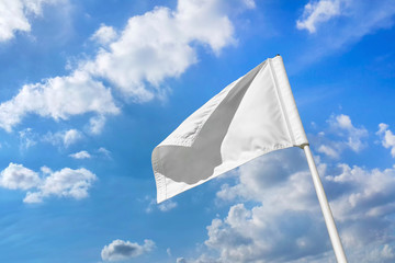 White golf flag with cloudy blue sky.