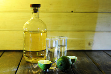 Alcoholic drink concept. Mexican tequila with lime and salt on rustic wood background. space for...