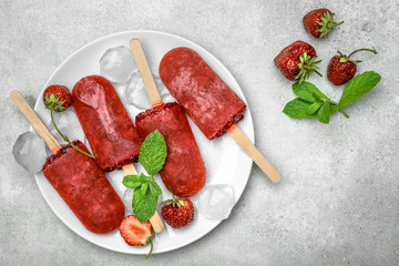 Fresh fruit popsicles with red strawberry, frozen sorbet. Juicy homemade ice cream with fruits, refreshing food concept.
