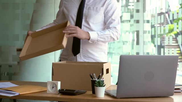 4k video of businessman has a brown cardboard box for resigning from work or unemployment and change job concept.