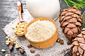 Flour cedar in bowl with nuts on dark wooden board