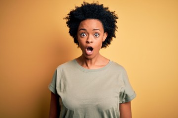 Fototapeta na wymiar Young beautiful African American afro woman with curly hair wearing casual t-shirt afraid and shocked with surprise expression, fear and excited face.