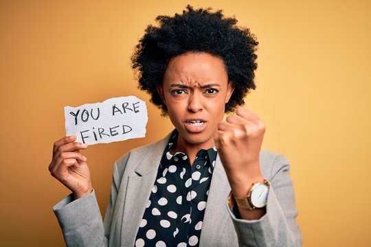 Young African American afro woman with curly hair holding paper with you are fired message annoyed and frustrated shouting with anger, crazy and yelling with raised hand, anger concept