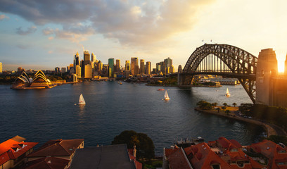 Fototapeta premium Punkt widokowy na port w Sydney z miastem i mostem w czasie zachodu słońca