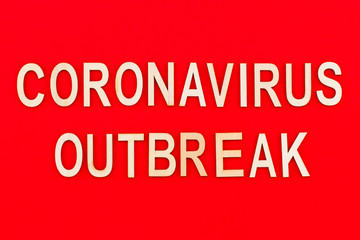 Сoronavirus outbreak. Text in wooden letters on a red background