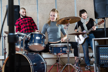 Fototapeta na wymiar Rehearsal of music group with female drummer