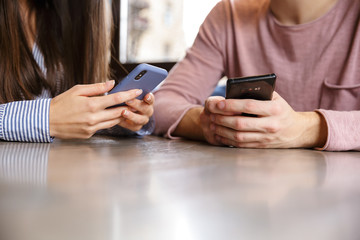 Close up of a young couple using mobile phone