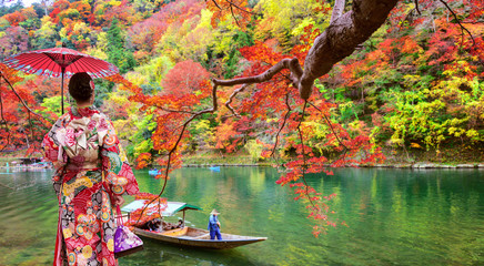 Naklejka premium Japanese girl wear traditional kimono dress and stand in arashiyama park