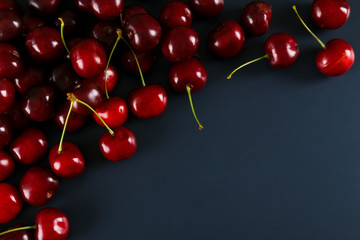Obraz na płótnie Canvas Bunch of fresh organic sweet cherries on textured background. Clean eating concept. Healthy nutritious vegan snack, raw diet. Close up, copy space, top view, flat lay.