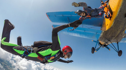 A group of skydivers jumping out of the plane