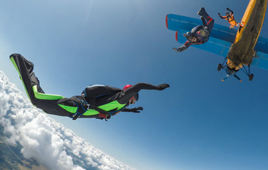 A group of skydivers jump out of the plane