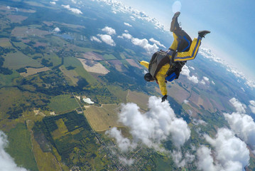 Skydive tandem free falling above the clouds