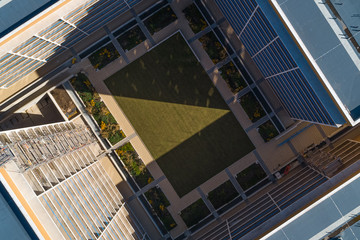 Fototapeta na wymiar Abstract high rise building with green quad centre from aerial drone