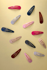 Colorful trendy hair clips on bright yellow background. Top view.