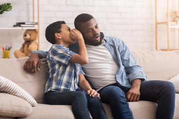 Little Afro Boy Whispering In Father's Ear, sharing secret