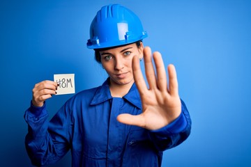 Beautiful worker woman wearing hardhat and uniform celebrating 8th march womens day with open hand doing stop sign with serious and confident expression, defense gesture