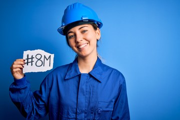 Beautiful worker woman wearing hardhat and uniform celebrating 8th march womens day with a happy face standing and smiling with a confident smile showing teeth