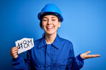 Beautiful worker woman wearing hardhat and uniform celebrating 8th march womens day very happy and excited, winner expression celebrating victory screaming with big smile and raised hands