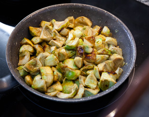 Appetizing artichokes fried in a pan