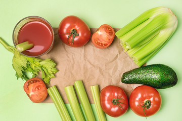 Background or Flat Lay with Glass of Tasty and Healthy Tomatoes and Celery Juice Raw Tomatoes Celery and Avocado on Green Background Top View Flat Lay Copy Space
