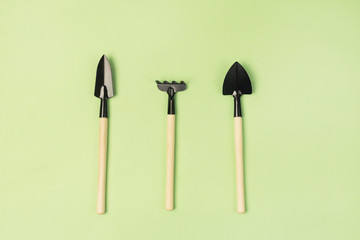 Garden Tools on Green Background Small Garden Rake and Garden Shovel Horizontal Top View Gardening...