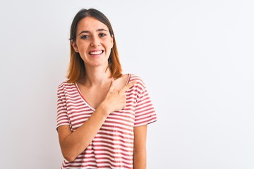 Beautiful redhead woman wearing casual striped red t-shirt over isolated background cheerful with a smile of face pointing with hand and finger up to the side with happy and natural expression on face