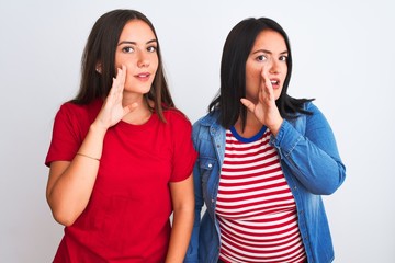 Young beautiful women wearing casual clothes standing over isolated white background hand on mouth telling secret rumor, whispering malicious talk conversation