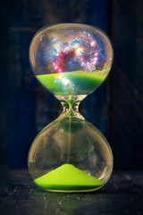 Space and galaxy in hourglass. Life time passing concept. Sand running through the bulbs of...