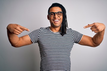 Young handsome african american man with dreadlocks wearing striped t-shirt and glasses looking...