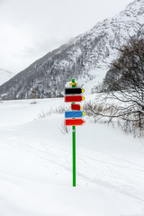Signs on the track for winter sports on a background of snow and alpine mountains